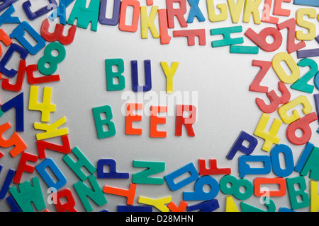 "Acquistare birra" - magnete da frigorifero magie un messaggio al di fuori di un'accozzaglia di lettere Foto Stock