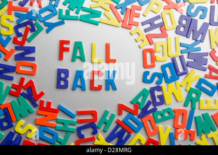 "Fall Back' - magneti da frigorifero scrivi un messaggio al di fuori di un'accozzaglia di lettere Foto Stock