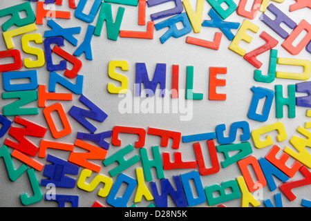 'Smile' - magneti da frigorifero scrivi un messaggio al di fuori di un'accozzaglia di lettere Foto Stock