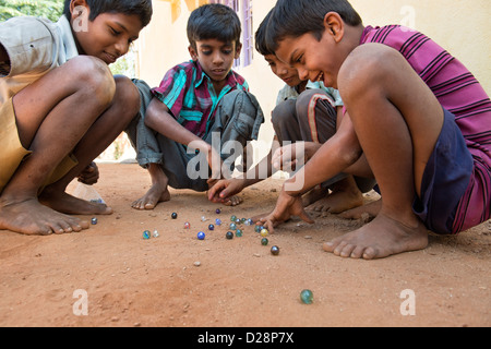 Ragazzi indiani la riproduzione di marmi in un territorio rurale villaggio indiano. Andhra Pradesh, India Foto Stock