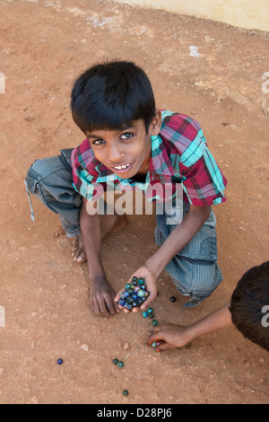 Ragazzi indiani la riproduzione di marmi in un territorio rurale villaggio indiano. Andhra Pradesh, India Foto Stock