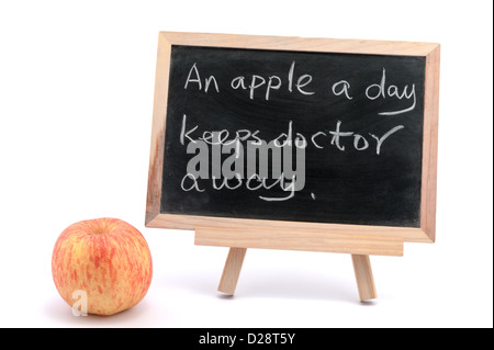 Una mela al giorno toglie il medico di distanza parole scritte sulla lavagna Foto Stock