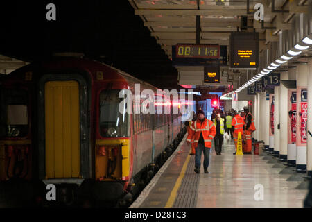 Londra, Regno Unito. Il 17 gennaio 2013. Funzionari della stazione sulla piattaforma accanto al treno dopo che il fuoco è stato spento. Credito: Pete Maclaine / Alamy Live News Foto Stock