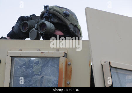 Hohenfels, Germania, 17 gennaio 2013. Un esercito sloveno soldato del 1° Brigata motorizzata tira la sicurezza accanto a un Humvee durante un militare di advisory team (MAT) esercizio presso la multinazionale comune disponibilità centro in Hohenfels, Germania, 17 Gennaio 2013tappetini e di polizia ai team di consulenza sono progettati per replicare l'Afghanistan ambiente operativo durante la preparazione di squadre per operazioni di counterinsurgency con la capacità di formare, consigliare e abilitare l'Afghanistan esercito nazionale e l'Afghanistan della polizia nazionale. (U.S. Esercito foto di Sgt. Gemma Iglesias/rilasciato) Foto Stock