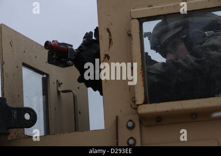 Hohenfels, Germania, 17 gennaio 2013. Un esercito sloveno soldato del 1° Brigata motorizzata tira la sicurezza accanto a un Humvee durante un militare di advisory team (MAT) esercizio presso la multinazionale comune disponibilità centro in Hohenfels, Germania, 17 Gennaio 2013tappetini e di polizia ai team di consulenza sono progettati per replicare l'Afghanistan ambiente operativo durante la preparazione di squadre per operazioni di counterinsurgency con la capacità di formare, consigliare e abilitare l'Afghanistan esercito nazionale e l'Afghanistan della polizia nazionale. (U.S. Esercito foto di Sgt. Gemma Iglesias/rilasciato) Foto Stock