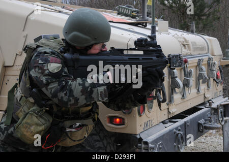 Hohenfels, Germania, 17 gennaio 2013. Un esercito sloveno soldato del 1° Brigata motorizzata tira la sicurezza accanto a un Humvee durante un militare di advisory team (MAT) esercizio presso la multinazionale comune disponibilità centro in Hohenfels, Germania, 17 Gennaio 2013tappetini e di polizia ai team di consulenza sono progettati per replicare l'Afghanistan ambiente operativo durante la preparazione di squadre per operazioni di counterinsurgency con la capacità di formare, consigliare e abilitare l'Afghanistan esercito nazionale e l'Afghanistan della polizia nazionale. (U.S. Esercito foto di Sgt. Gemma Iglesias/rilasciato) Foto Stock