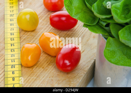 Insalata di pomodori e nastro di misurazione - la dieta e il mangiare sano; la perdita di peso concept Foto Stock