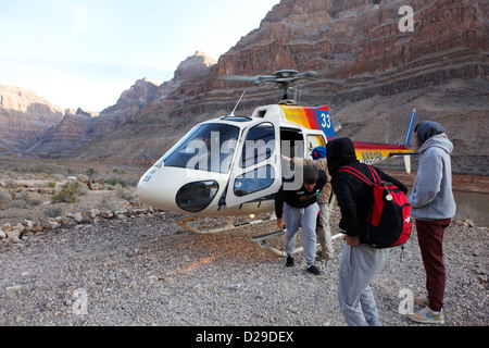 I passeggeri scendono dal papillon tour in elicottero è atterrato su pad giù nel Grand Canyon Arizona USA Foto Stock
