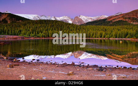 Il cielo e picchi di indiani delle Montagne Rocciose inizia a brillare al di sopra del lago di Brainard in Colorado su un vivace mattina in autunno Foto Stock