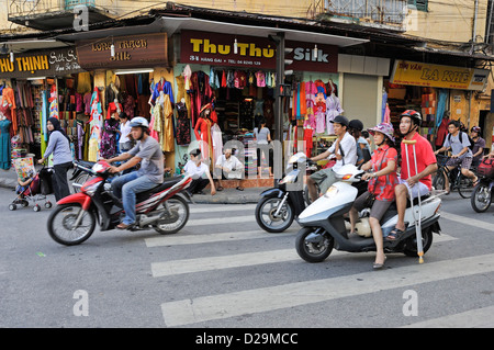 Hanoi, Vietnam, scena di strada con traffico a un incrocio stradale e persone in bicicletta Foto Stock
