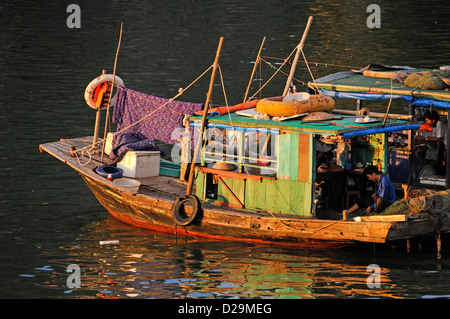 Vietnam, ha Long Bay, ha Long Bay al tramonto / crepuscolo - con pescatori Foto Stock