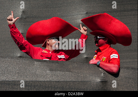 Due entusiasta texano tifosi della Ferrari Formula 1 racing team sporting enorme, rosso cappelli da cowboy e faccia la vernice. Foto Stock