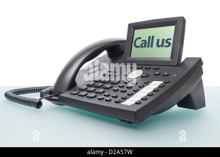 Moderno business voip phone sulla scrivania in vetro con le parole - Call us - nel display Foto Stock