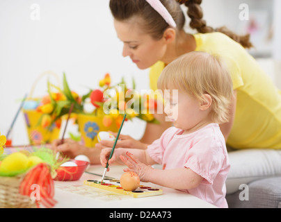 La madre e il bambino rendendo decorazioni di Pasqua Foto Stock