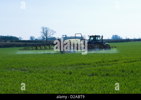 Trattore tirando meccanica nel campo di coltivazione Foto Stock