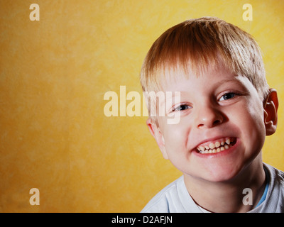 Ritratto di felice gioiosa bello piccolo ragazzo isolato su sfondo giallo Foto Stock