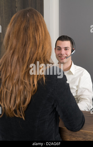 Il cliente ottenere alcune informazioni a un service desk Foto Stock