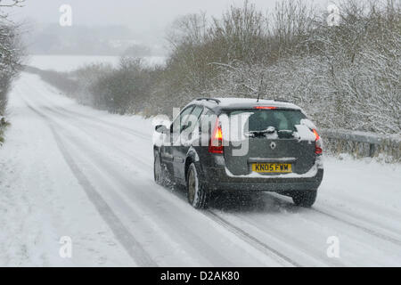 Chester Regno Unito. 18 gennaio, 2013. Una vettura viaggia lungo una coperta di neve strada nella periferia di Chester Regno Unito. Foto Stock