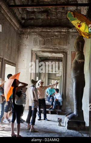 Una guida turistica mostra un gruppo di turisti in giro Ankor Wat. Angkor Wat si trova a 5,5 km a nord della moderna città di Siem Reap. Foto Stock