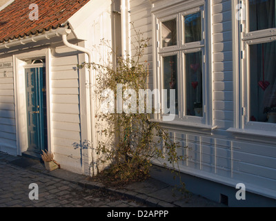 Dettaglio della strada di ciottoli nella vecchia Stavanger Norvegia. Caratteristico vecchio bianco con pannelli in legno case da sailship ser Foto Stock