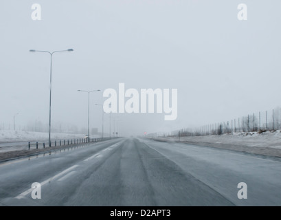 La scarsa visibilità, scarse condizioni di guida, nevischio, nebbia e neve in autostrada, tipico paesaggio invernale in Norvegia Foto Stock