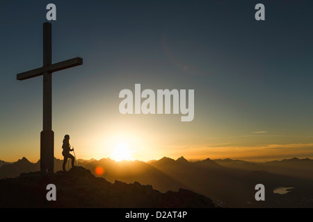 Escursionista in piedi dalla croce sulla collina rocciosa Foto Stock