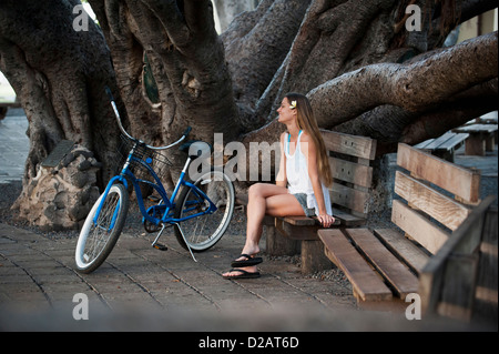 Donna seduta su una panchina nel parco Foto Stock