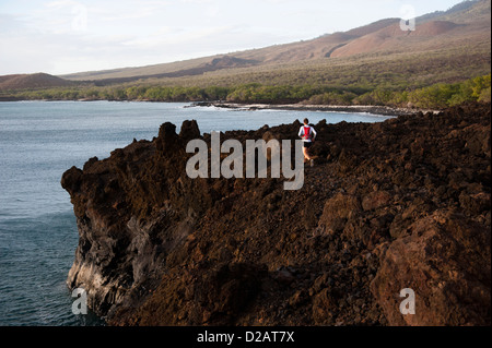 Uomo che corre sul roccioso sentiero rurale Foto Stock