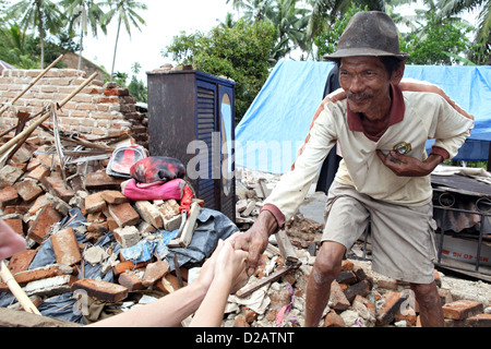 Sungai Rambai, Indonesia, un interessato uomo anziano davanti alla sua casa distrutta Foto Stock