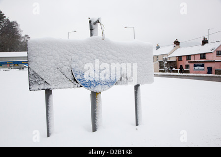 Mantenere la sinistra cartello stradale sulla rotonda ricoperta di neve, Abergavenny, Wales, Regno Unito Foto Stock