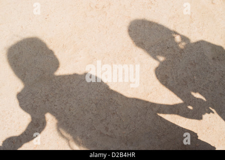 Ombra del villaggio indiano di bambini in una linea tenendo le mani per giocare. Andhra Pradesh, India Foto Stock