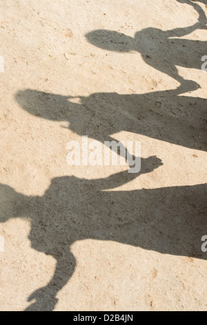 Ombra del villaggio indiano di bambini in una linea tenendo le mani per giocare. Andhra Pradesh, India Foto Stock