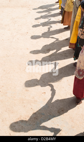 Ombra del villaggio indiano di bambini in una linea tenendo le mani per giocare. Andhra Pradesh, India Foto Stock