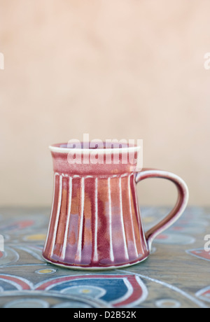 Il tè rosso o tazza da caffè in ceramica o tazza per bere copybook e pen  tray nero su beige sfondo testurizzato, spazio di copia Foto stock - Alamy