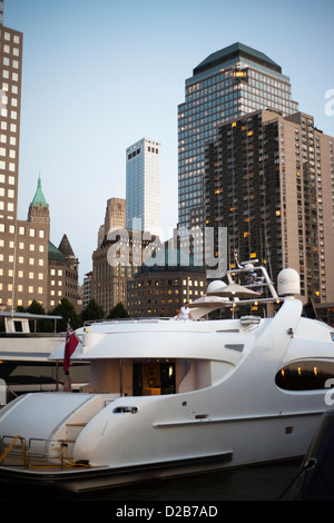 Imbarcazioni a motore di lusso in North Cove al crepuscolo con inferiore dello skyline di Manhattan al di là. Foto Stock