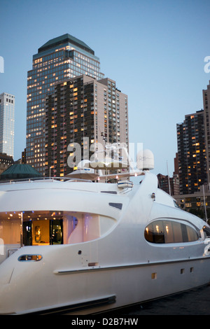 Imbarcazioni a motore di lusso al crepuscolo con inferiore dello skyline di Manhattan al di là. Foto Stock