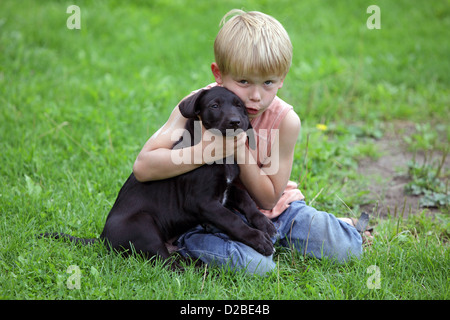 Villaggio splendente, Germania, ragazzo di coccole con un cucciolo Foto Stock