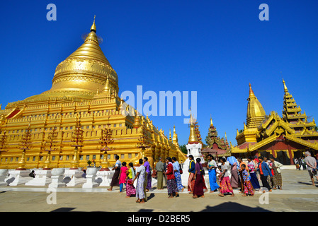 Pellegrini a piedi intorno alla Shwezigon Paya pagoda dorata in Paya, Bagan, Myanmar. Foto Stock