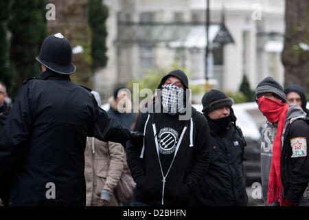 Londra, UK, 19 gennaio 2013 mascherata anti fascisti sono impedito dalla polizia di avvicinarsi alle loro controparti fascista in un rally da anti fasciste contro l'estrema destra greco "Golden Dawn' party. Il rally presso la sede dell' ambasciata di Grecia nella zona londinese di Holland Park si svolge in collaborazione con gli altri in tutta Europa, con un raduno nazionale di Atene. Foto Stock