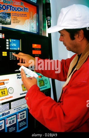 Uomo che utilizza automatizzato di pompa in corrispondenza della stazione di gas. Credito accetta /carte di debito; il sistema video Foto Stock