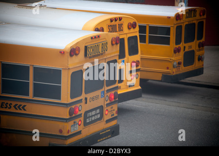 Gli autobus scolastici in attesa di licenziamento sono parcheggiate al di fuori di una scuola elementare in New York quartiere di Chelsea Foto Stock