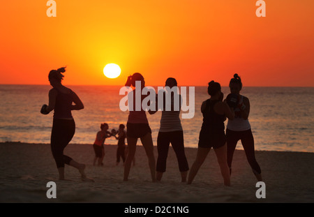 Donna esercizio "boot camp' durante il Sunrise a Sydney la famosa Bondi Beach in una ondata di caldo giorno. Foto Stock