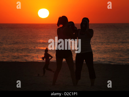 Donna esercizio "boot camp' durante il Sunrise a Sydney la famosa Bondi Beach in una ondata di caldo giorno. Foto Stock