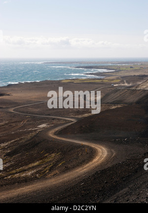Un avvolgimento S-curva da una strada sterrata lungo la costa dell'Islanda che mostra il paesaggio e l'oceano con abbondanza di spazio di copia per il testo Foto Stock