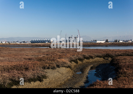 Un sale di palude e wetland Wildlife Refuge sulla Baia di San Francisco con un impianto di alimentazione essendo costruito in corrispondenza del suo bordo. Foto Stock