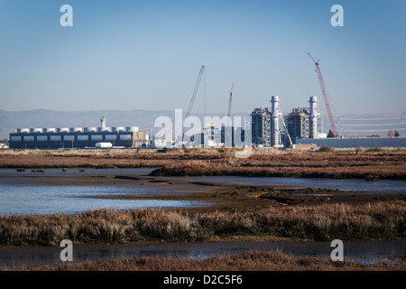 Impianto di alimentazione in costruzione in corrispondenza di un bordo di una palude salata e wetland Wildlife Refuge sulla Baia di San Francisco. Foto Stock