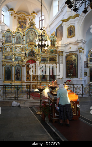 Minsk, Bielorussia, credulone vecchia donna di fronte all'altare nella Cattedrale dello Spirito Santo Foto Stock