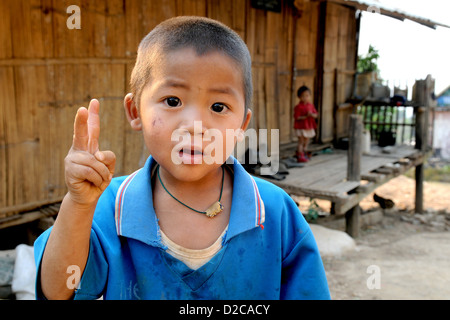 Taunggyi, Myanmar, triste Fluechtlingsjunge mostra il segno della vittoria Foto Stock