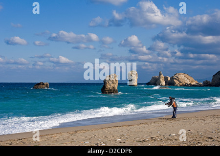 L'uomo la pesca sulla spiaggia rocciosa in inverno Foto Stock