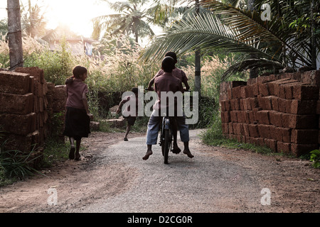 14/11/2011, Kerala, India: i bambini sono il ciclismo in un villaggio road. Foto Stock